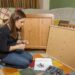 Girl reading instructions to assemble furniture