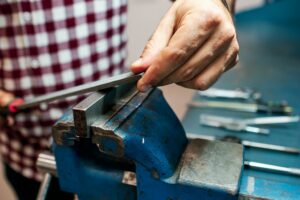 Grinding a block of metal with a file