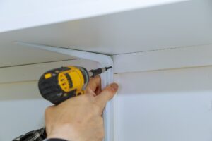 Man installing wooden shelves on brackets installation of shelves