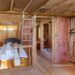 Mineral glass wool in a warming the walls with fiberglass on a inclined wall near the wooden ceiling